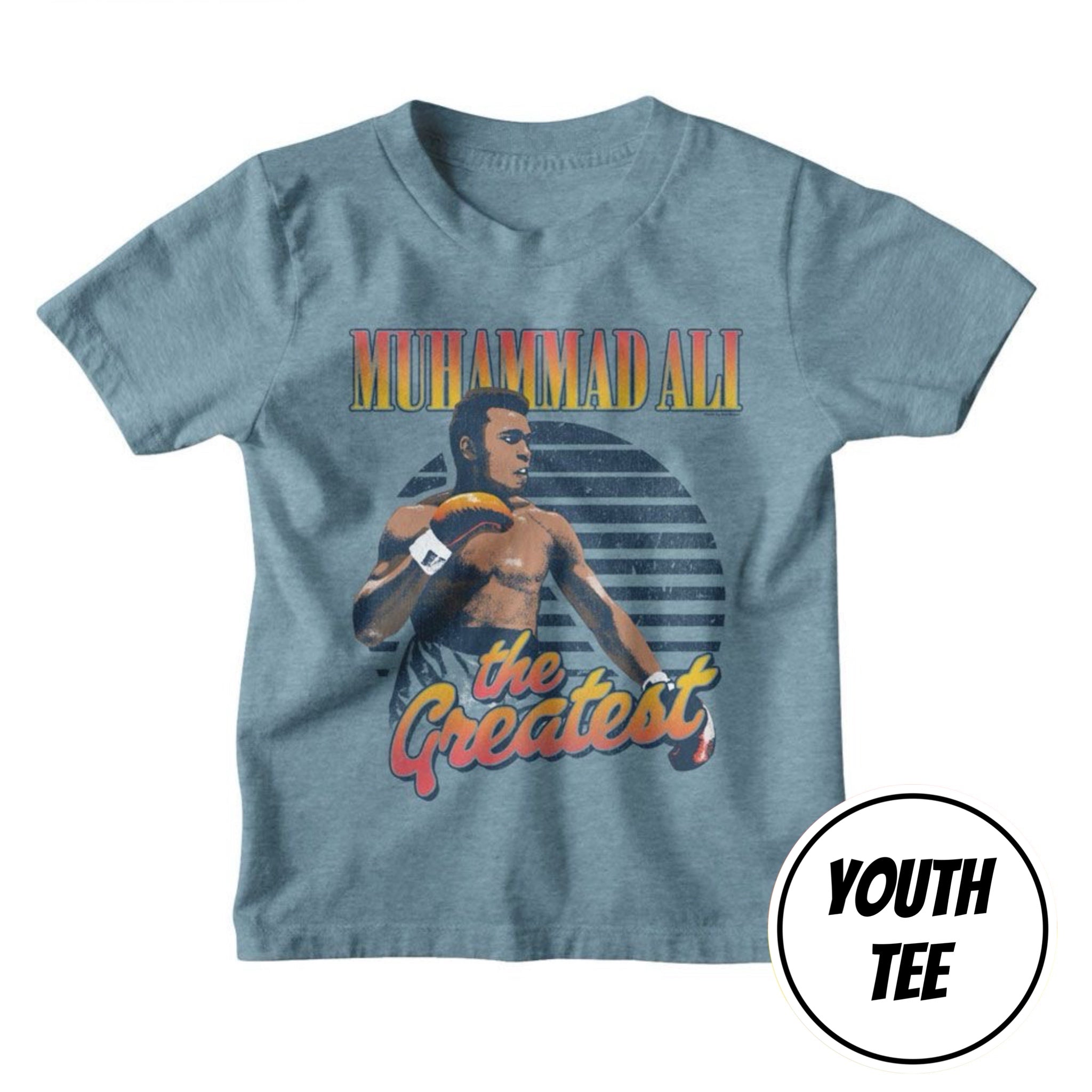A youth heather blue t-shirt featuring a graphic of Muhammad Ali with the text 'MUHAMMAD ALI' and 'the Greatest,' on a white background with a 'YOUTH TEE' badge overlay.