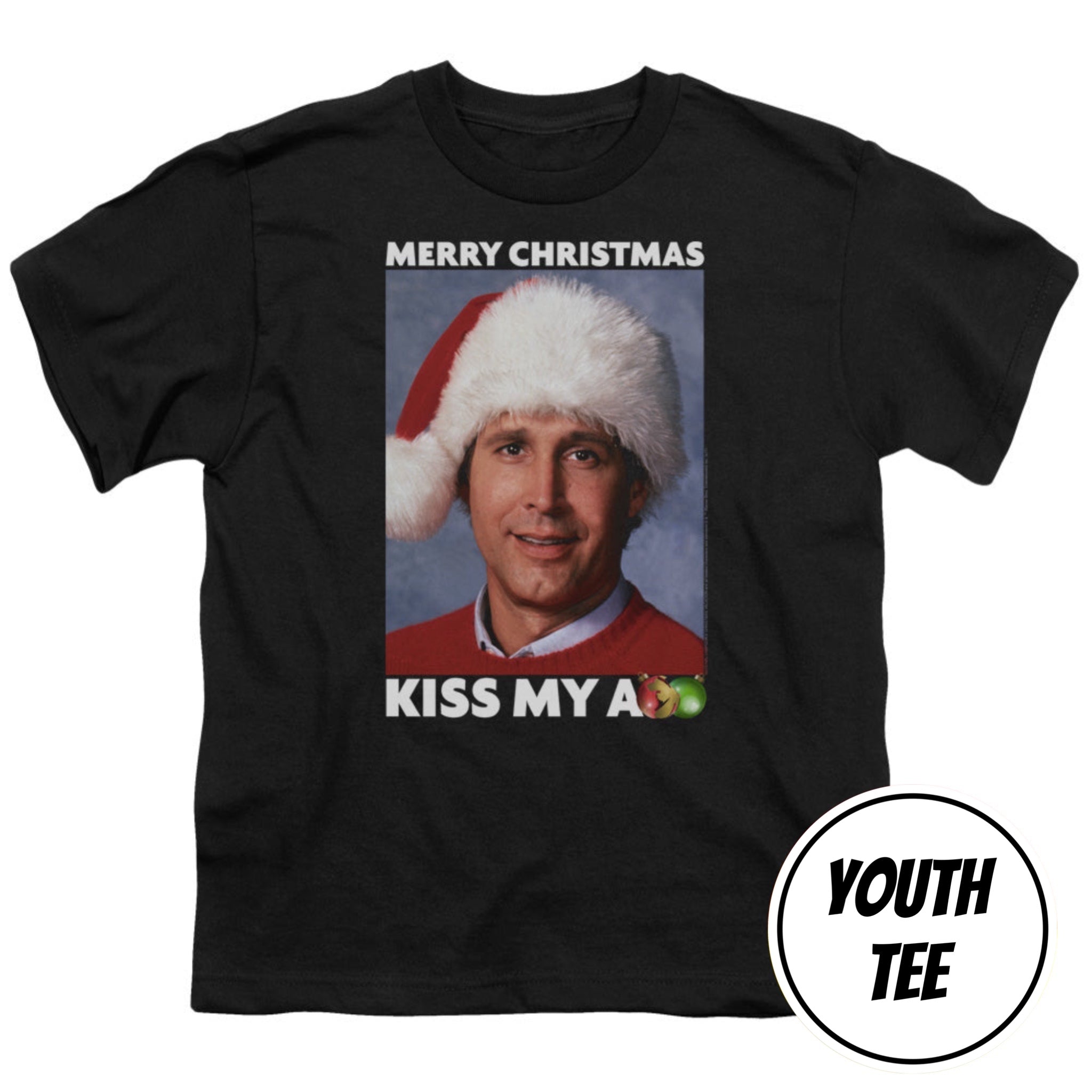 A black youth t-shirt featuring a graphic print of a man in a Santa hat with the text 'MERRY CHRISTMAS' and 'KISS MY A' with a small green apple graphic. A white circular badge in the bottom right corner reads 'YOUTH TEE'.