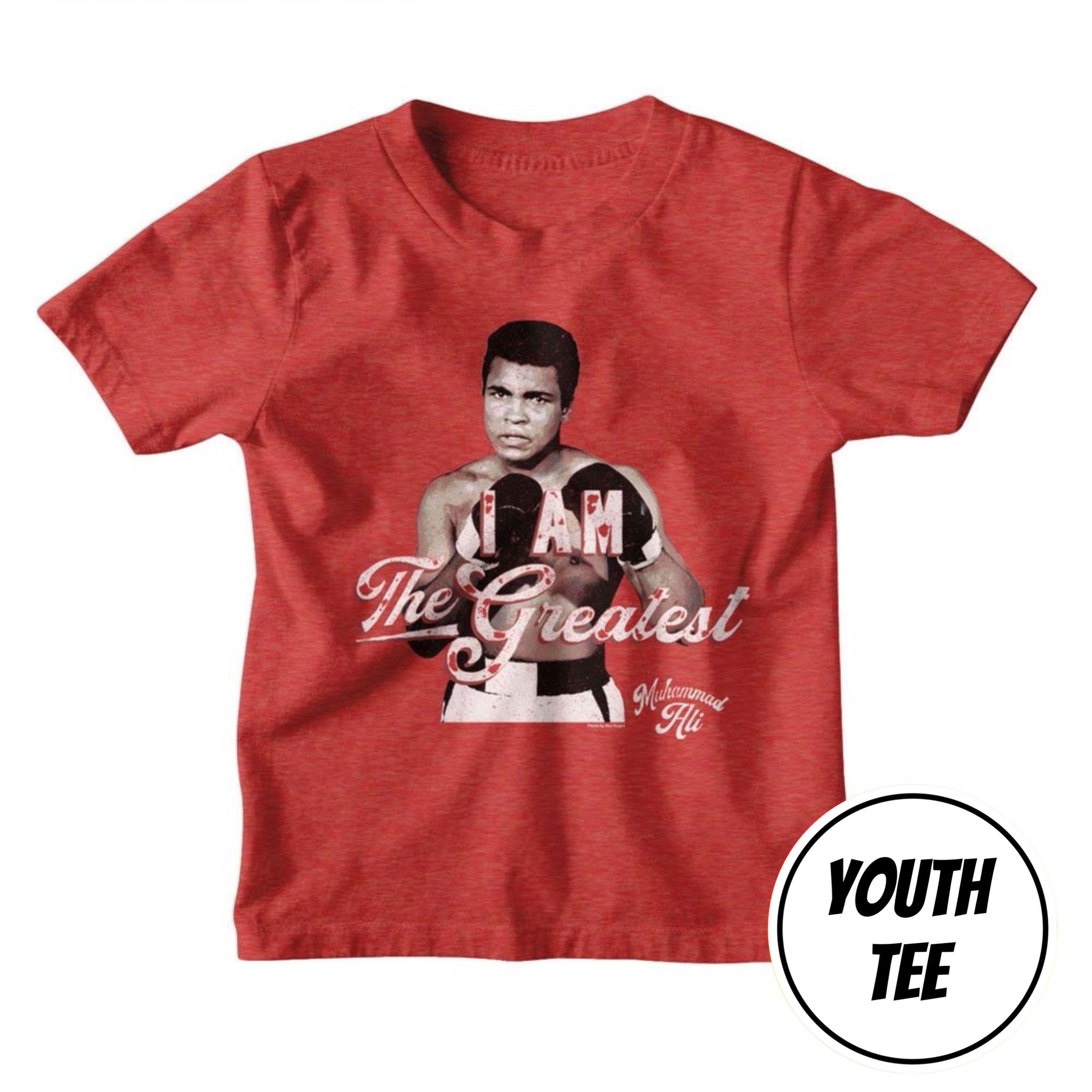 A youth heather red t-shirt featuring a graphic of Muhammad Ali in boxing gear with the text 'The Greatest' and 'Wounded 4'. A circular 'YOUTH TEE' label is in the bottom right corner.
