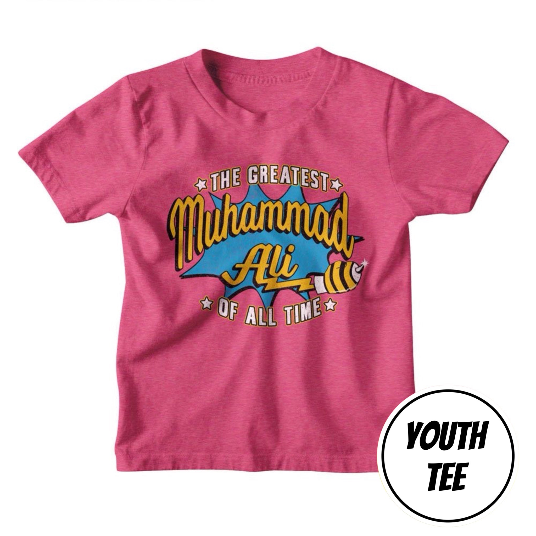 A youth heather pink t-shirt featuring a colorful graphic print of Muhammad Ali with the text 'THE GREATEST Muhammad Ali OF ALL TIME' in a comic-style speech bubble. A circular badge in the bottom right corner reads 'YOUTH TEE'.