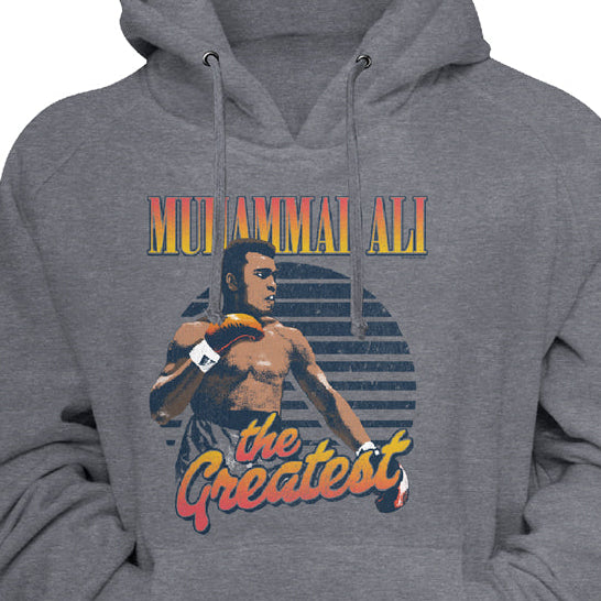 A heather gray pullover hoodie featuring a graphic print of Muay Thai artist Pet Kiatnoi with the text 'MET AMMAZING ALL THE Greatest' in a retro orange and yellow font, shown against a plain white background.
