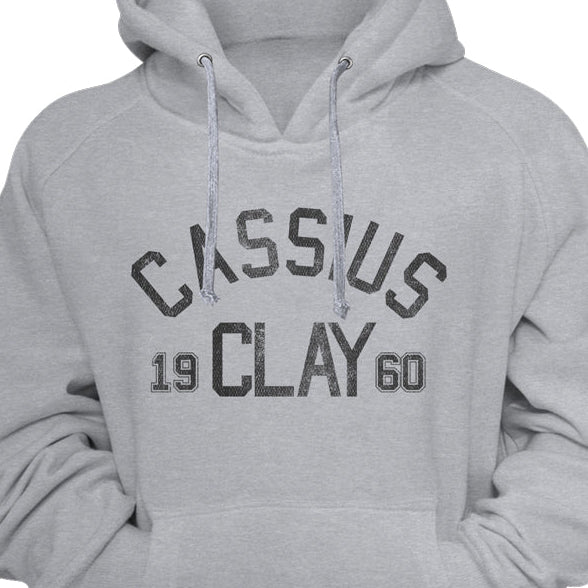 A light gray pullover hoodie with a distressed black graphic on the chest reading 'CASSIUS 19 CLAY 60', shown against a gray background.