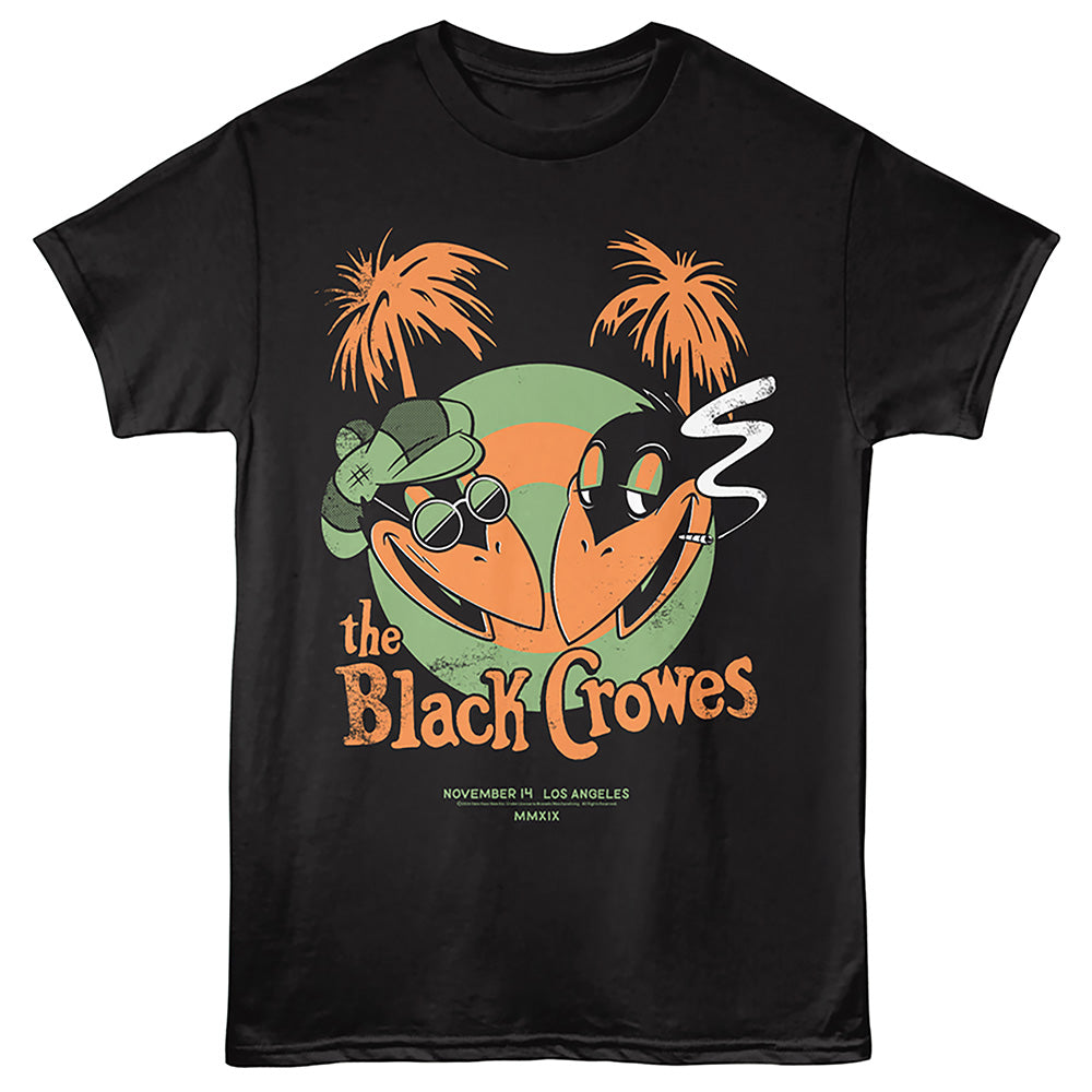 A black short-sleeve graphic t-shirt featuring a cartoon illustration of two black-crow-like birds wearing sunglasses and a green hat, with orange palm trees and the text 'the Black Crowes' on the front.