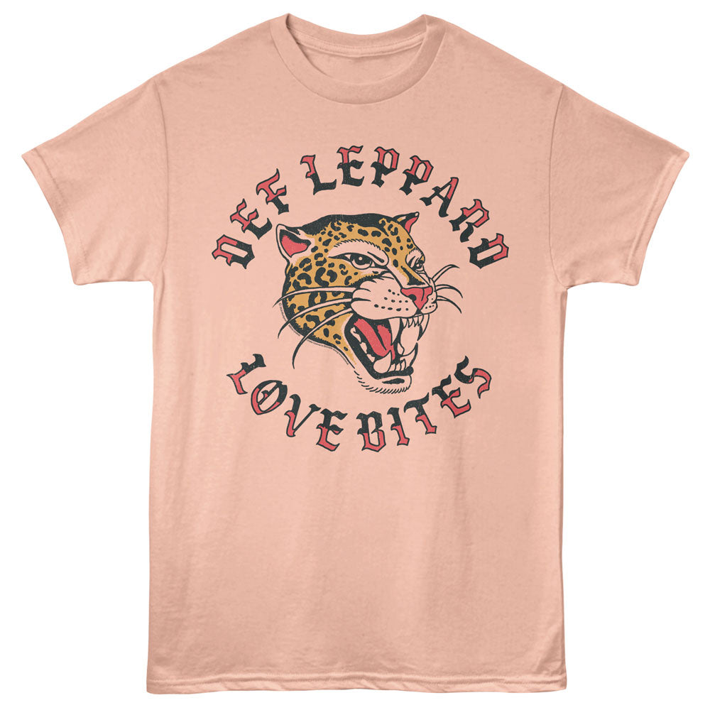 A peach-colored short-sleeve t-shirt featuring a graphic print of a roaring leopard with the text 'DEF LEPPARD' above and 'LOVE BITES' below in a stylized red and black font.