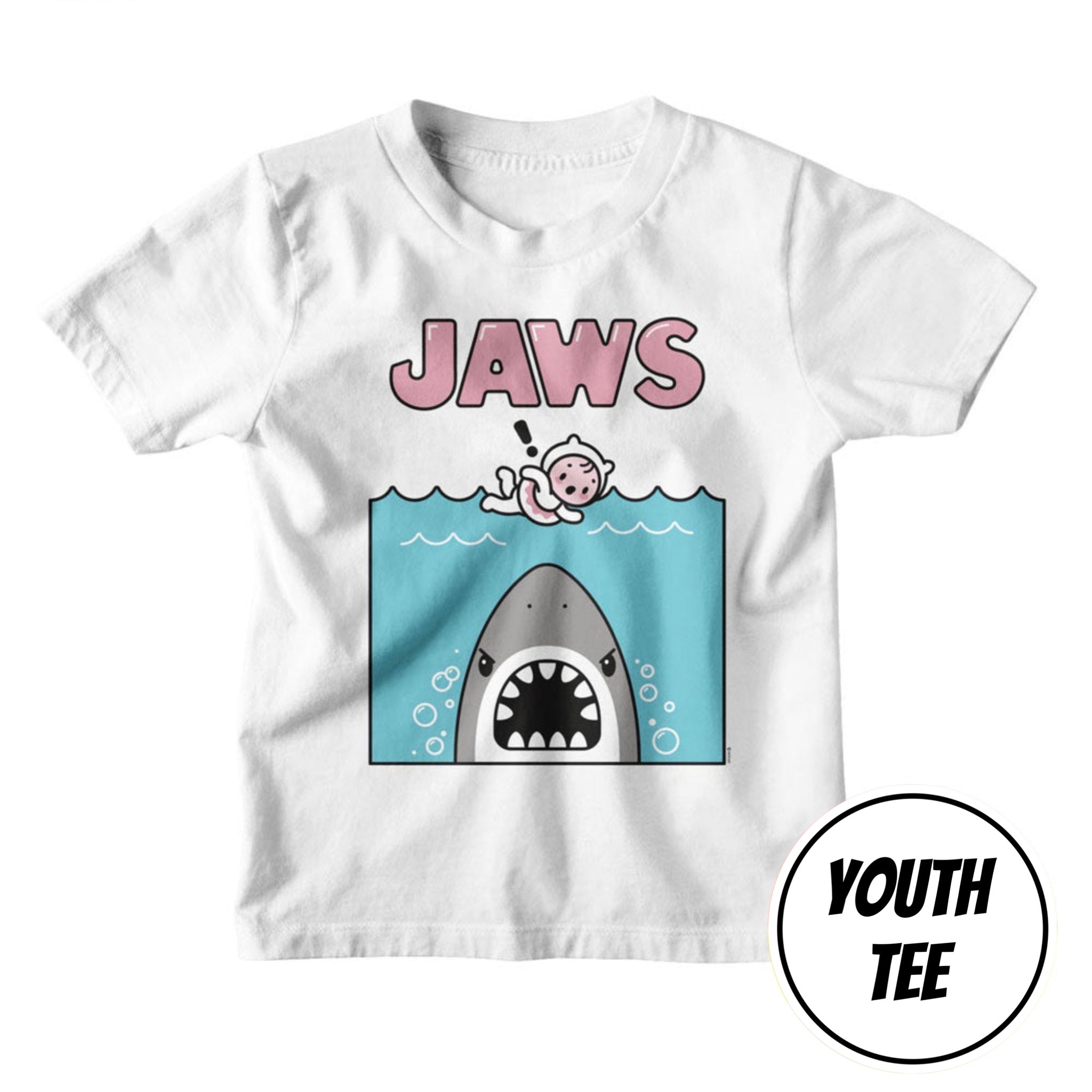 A white youth short-sleeve t-shirt featuring a cartoon graphic of a shark in the water with a baby floating above it and the word 'JAWS' in pink letters. A circular badge in the bottom right corner reads 'YOUTH TEE'.