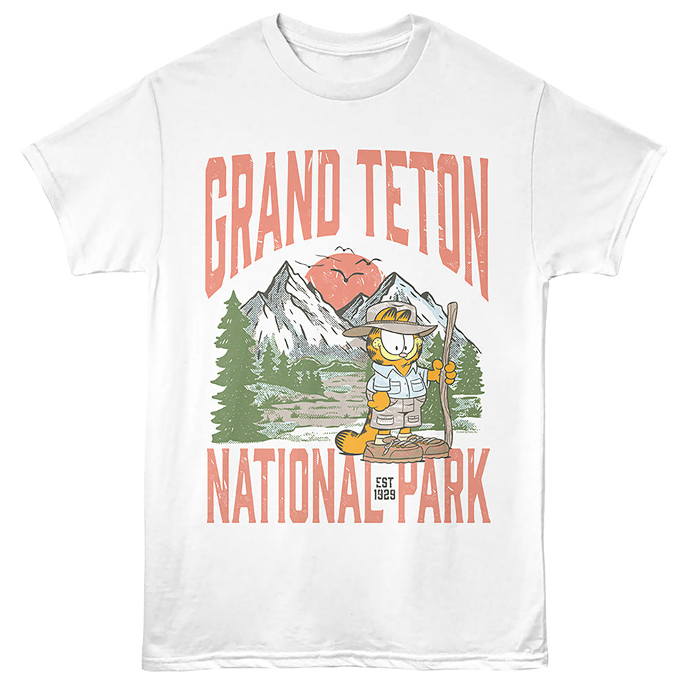 A white short-sleeve crewneck t-shirt featuring a colorful graphic print of Garfield hiking in front of mountains with the text 'GRAND TETON NATIONAL PARK' in coral pink.