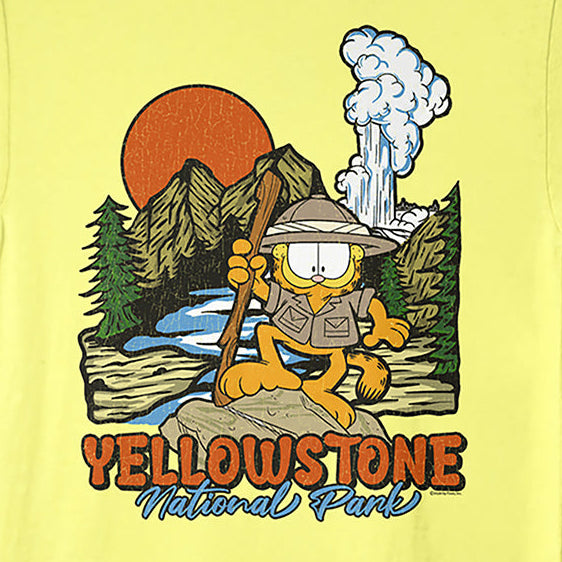 A pale yellow short-sleeve t-shirt featuring a colorful graphic of Garfield as a hiker in Yellowstone National Park, with an orange sun, mountains, and the text 'YELLOWSTONE National Park' printed below.