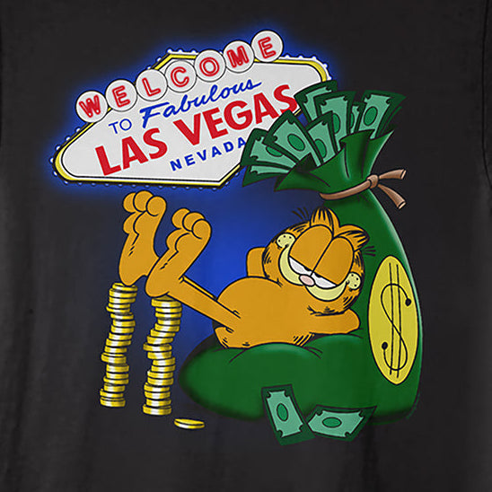A black short-sleeve crewneck t-shirt featuring a colorful graphic print of Garfield lounging next to a green money sack and the 'Welcome to Fabulous Las Vegas' sign.
