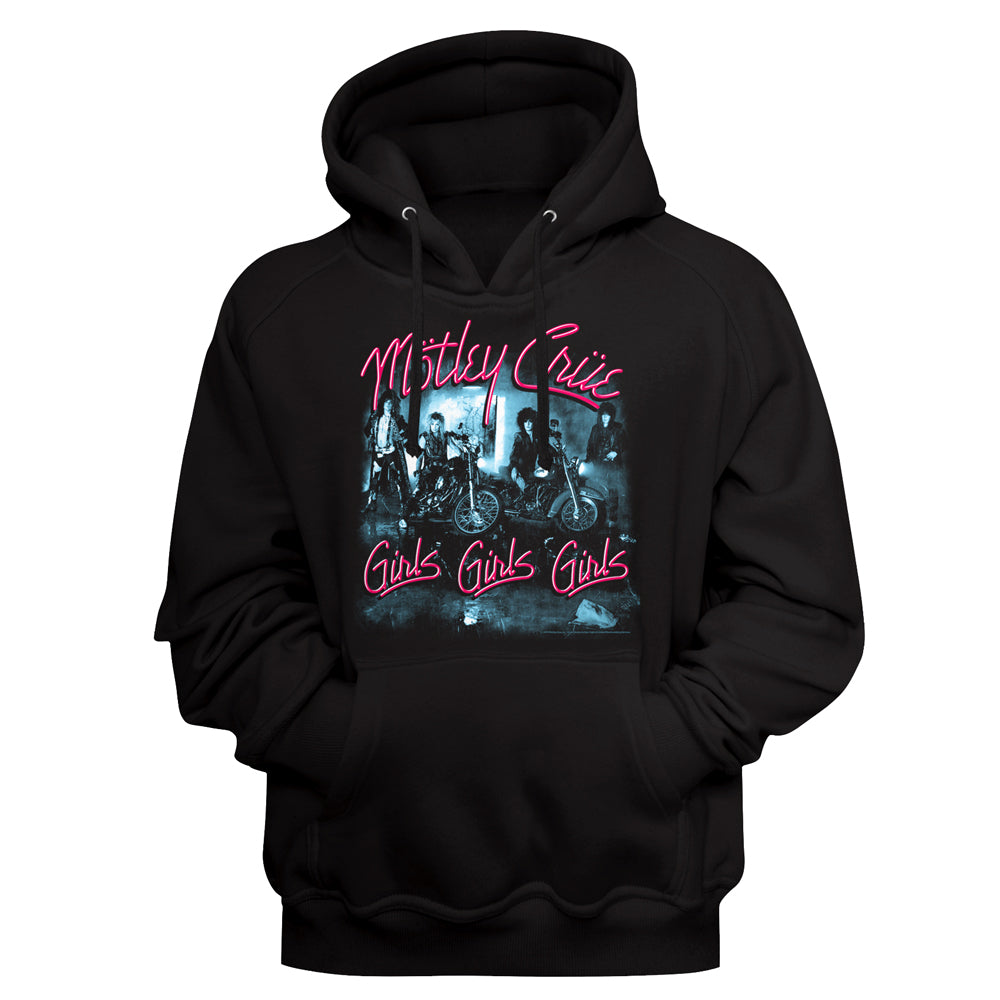 A black pullover hoodie featuring a front graphic print of the band Motley Crue with their 'Girls Girls Girls' album artwork. The text is written in a vibrant pink neon-style font, and the central graphic depicts the band members on motorcycles in a dark, moody blue-toned scene.