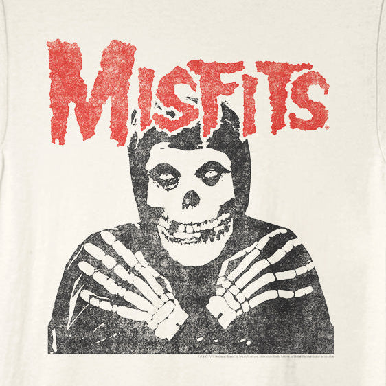 An off-white ringer t-shirt with black trim on the collar and sleeves, featuring a distressed red 'MISFITS' logo and a black-and-white graphic of a skeleton in a hood on the front.