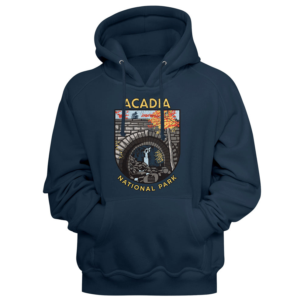 A navy blue pullover hoodie featuring a graphic print of Acadia National Park on the chest, displayed against a navy background.