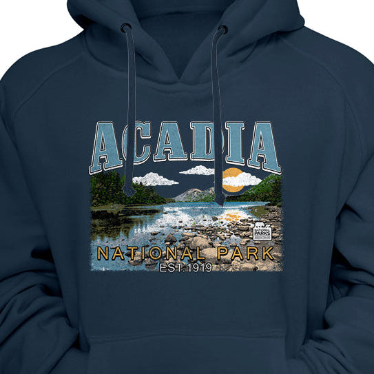 A navy blue pullover hoodie with a front graphic print featuring the word 'ACADIA' and a scenic landscape illustration of Acadia National Park.