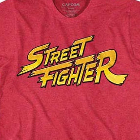 A heather red short-sleeve t-shirt featuring a large yellow and black 'Street Fighter' graphic printed across the chest, displayed flat against a red background.